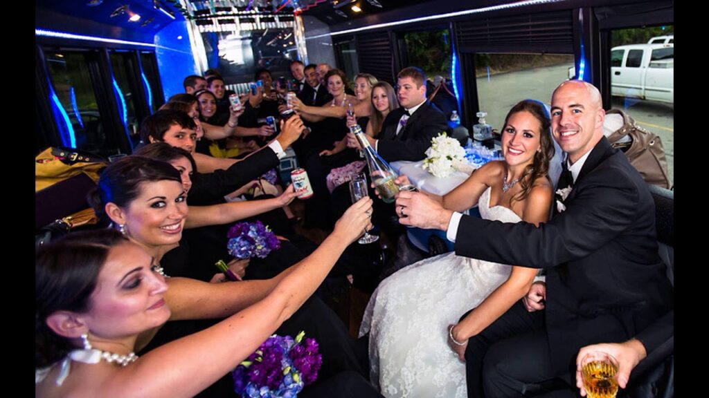 Bride and groom in a wedding limo celebrating with their bridal party, raising glasses for a toast inside a party-style limousine with blue lighting.